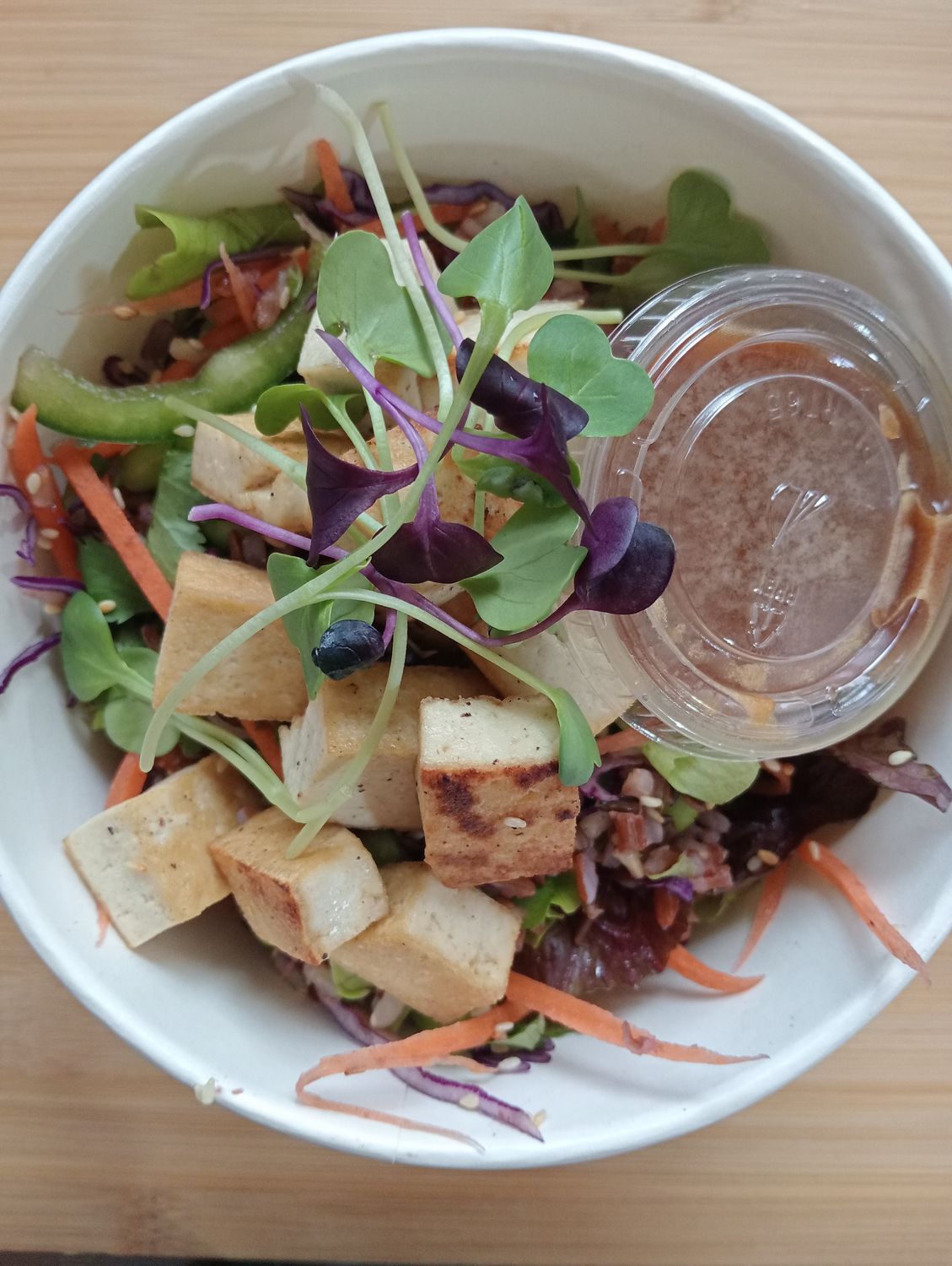 SALAD ASIA. julienne carrots, capsicum, cabbage, spring onions, steamed edamame beans, coriander, salad greens and rice with panfried tofu, sesame seeds and soy-sesame- honey-lime vinaigrette.