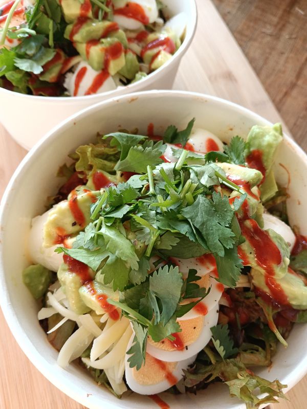 BURRITO BOWL Salad greens with spiced black beans, corn, capsicum, tomato, red onion, grated edam, sour cream, avocado, coriander, sriracha sauce.