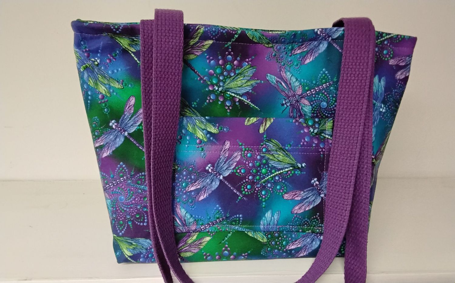 Elegant dragonflies in purple, green, and blue, purple straps