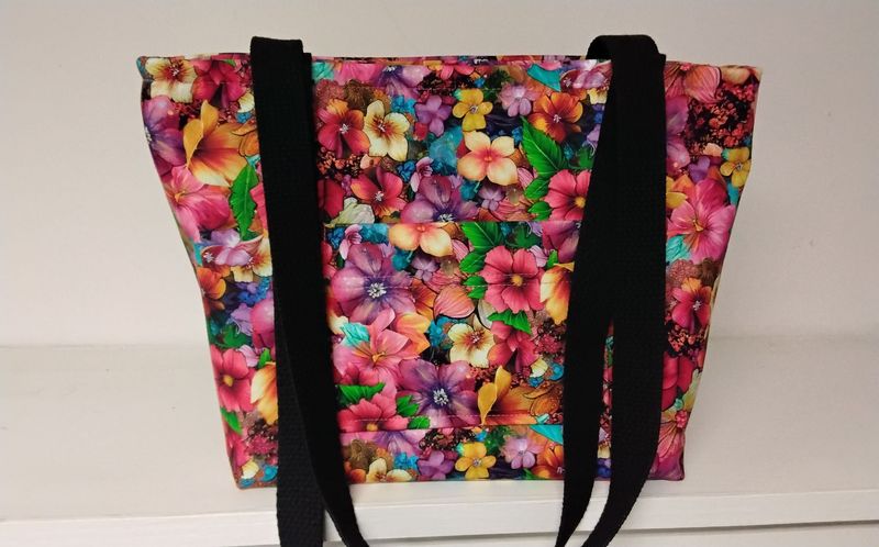 Bright floral print in rich pinks and reds, black straps