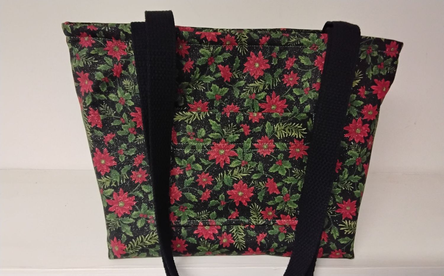 Red poinsettias with greens on black, black straps