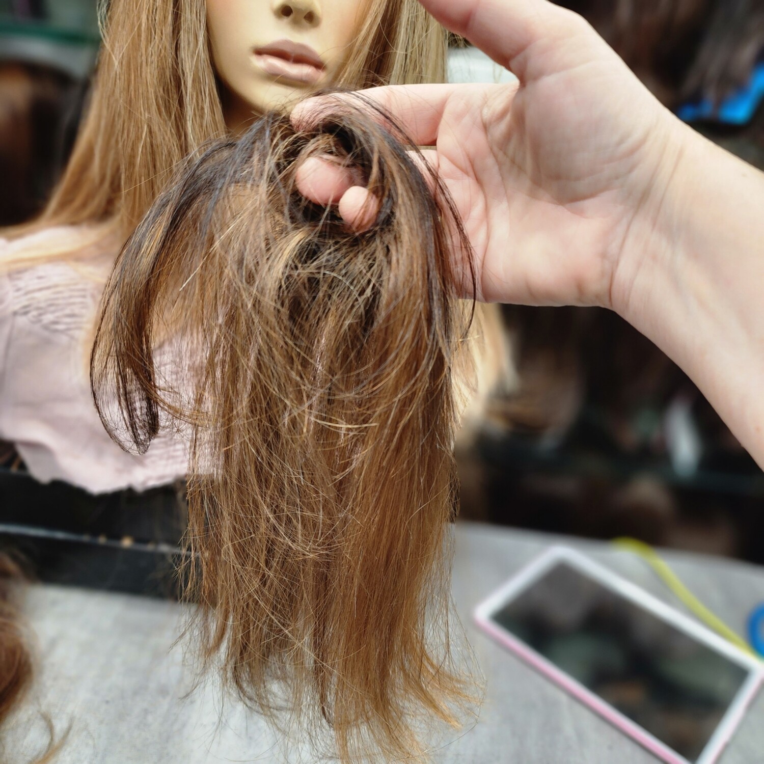 Chouchou en cheveux naturels clairs avec reflets, tenu à la main