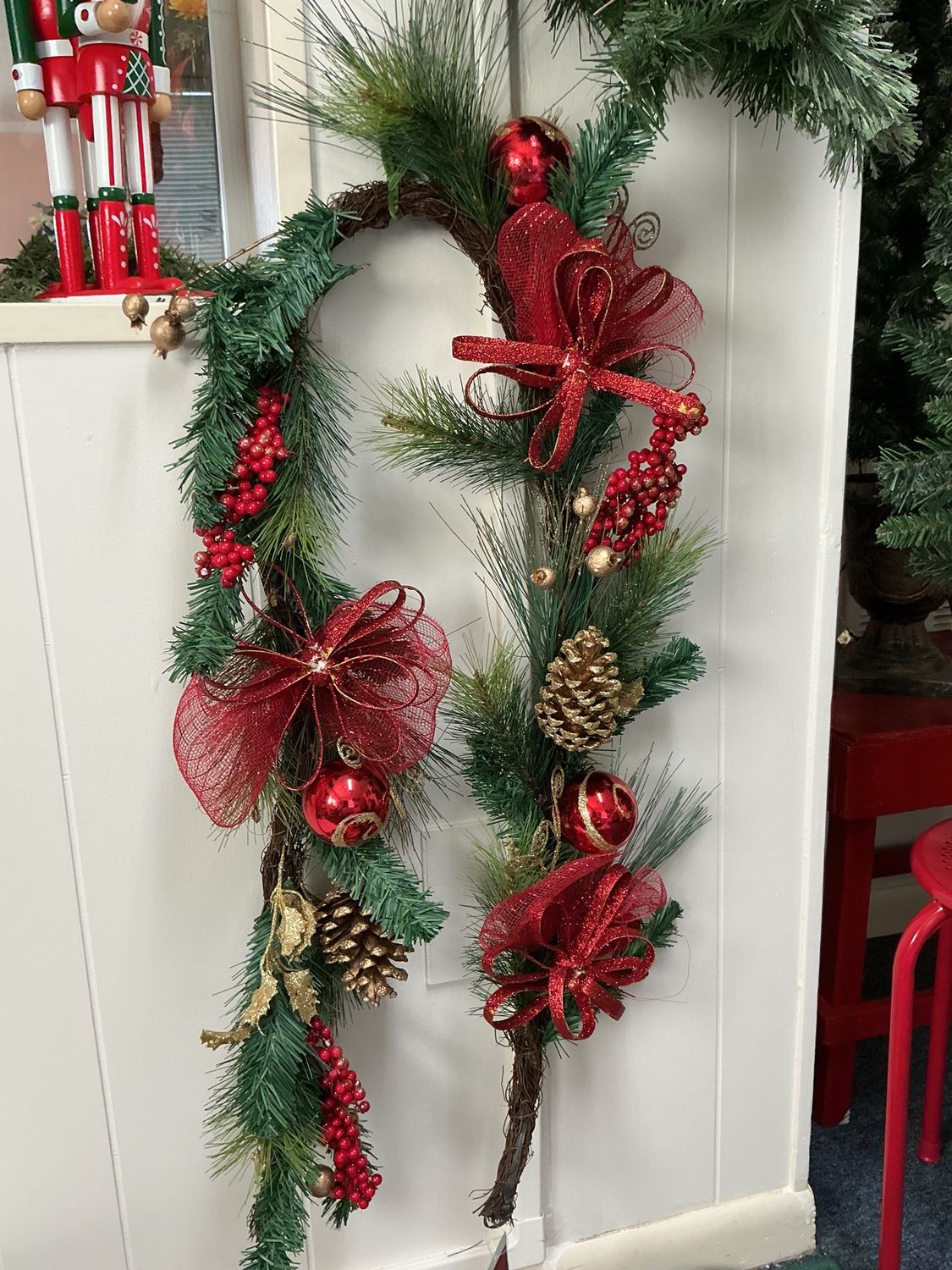 greenery with red balls and pinecones and red bows for mantel