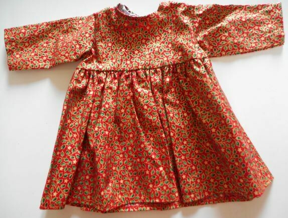 Dress for dolls in red, green and gold holly and star print. Dress for dolls in red, green and gold holly and star print.