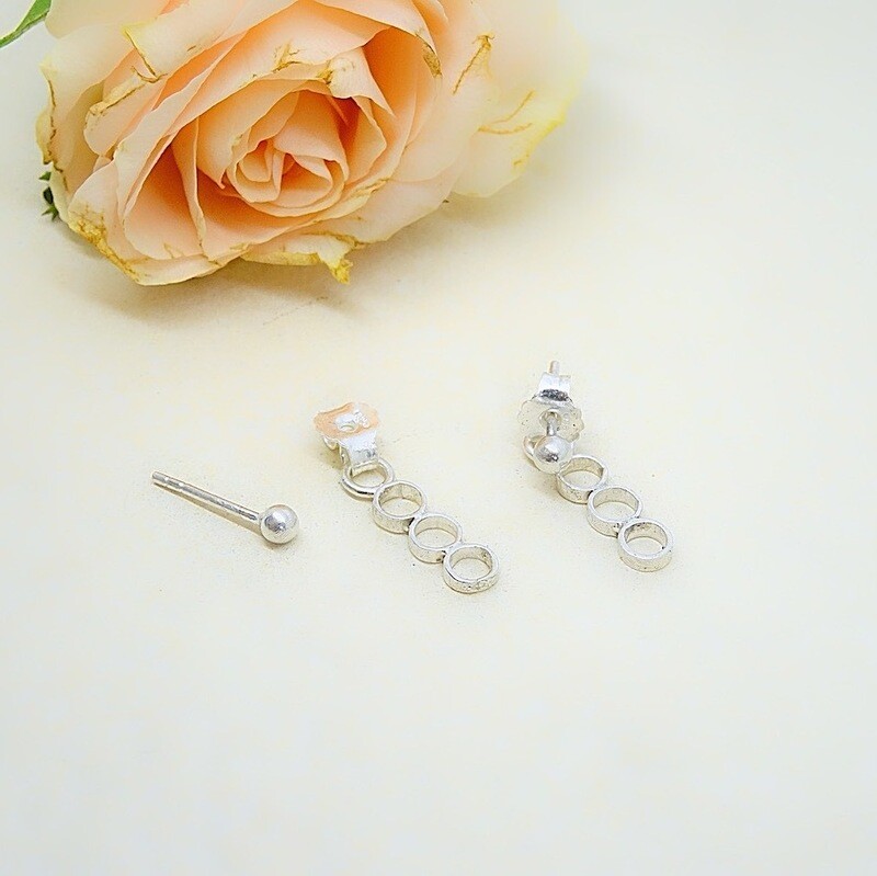 Silver stud earrings with circles behind the ear - Harry TiLLEY jewelry