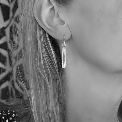 Silver earrings with a curved shape. Handmade by the Harry TiLLEY studio.