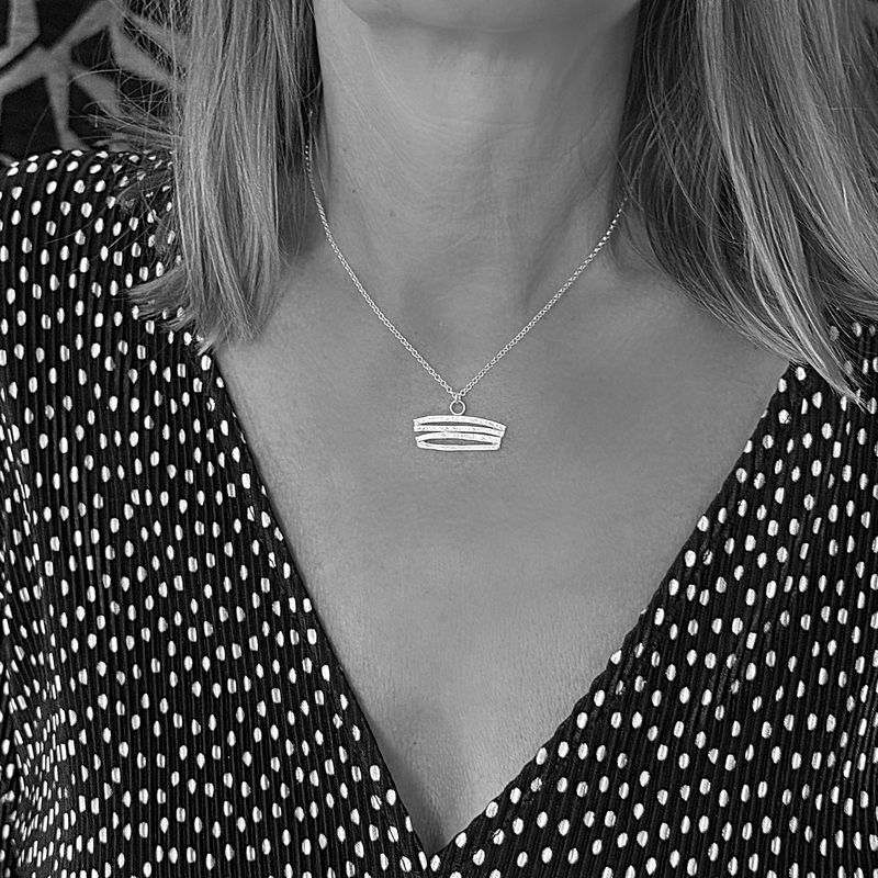 Silver pendant with curved shapes! Available in white or gold-plated silver at Harry TiLLEY.