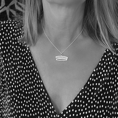 Silver pendant with curved shapes! Available in white or gold-plated silver at Harry TiLLEY.