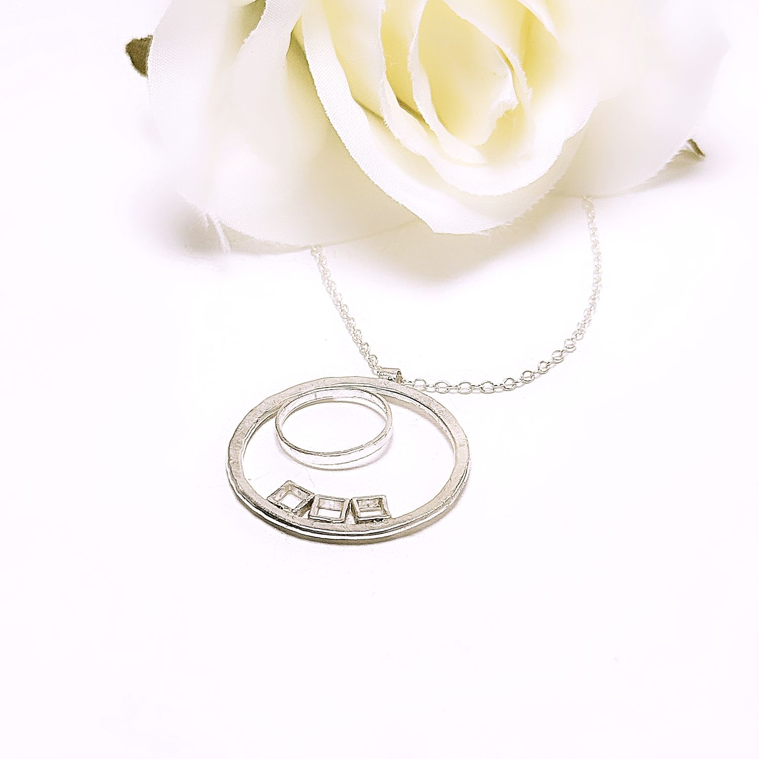 Silver circle pendant with small circle and three squares