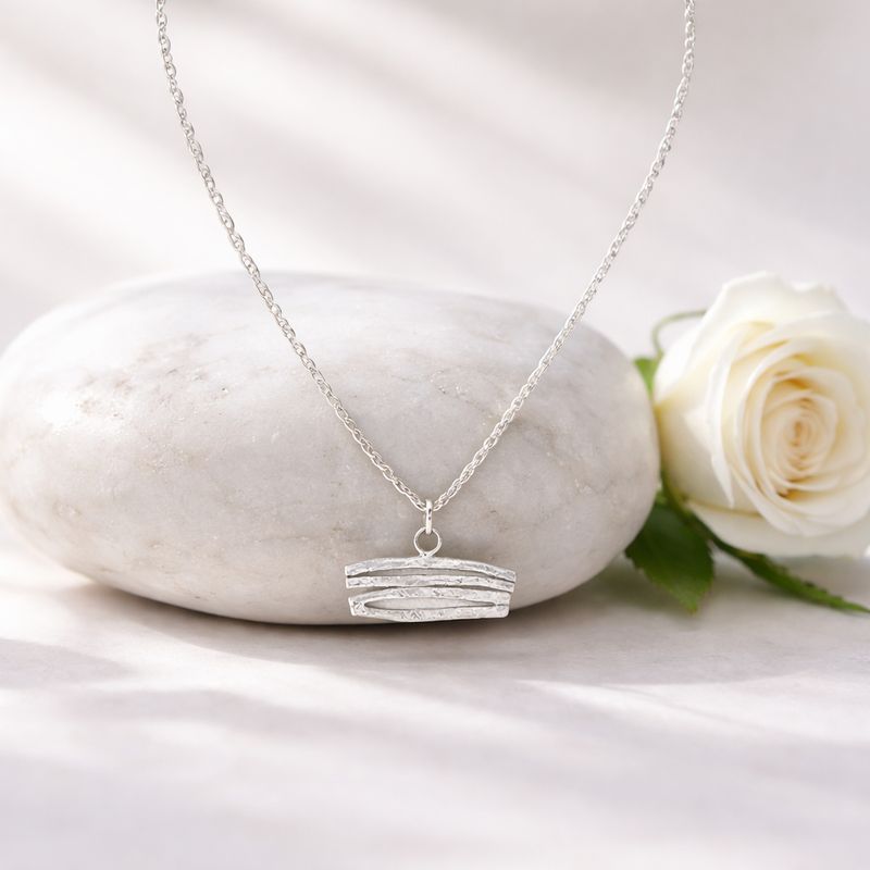 Silver pendant with curved shapes! Available in white or gold-plated silver at Harry TiLLEY.
