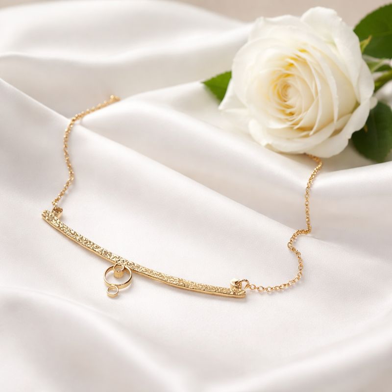 Silver necklace with a curved shape and circles. Handmade in the Harry TiLLEY studio.