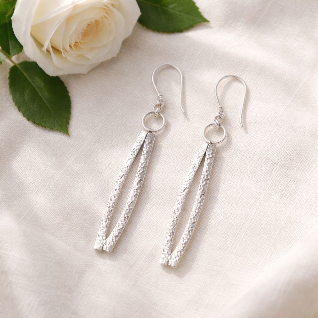 Silver earrings with a curved shape. Handmade by the Harry TiLLEY studio.