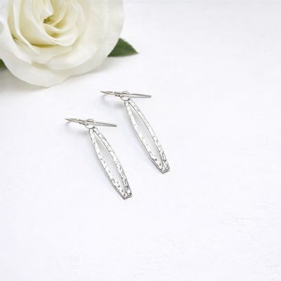 Silver earrings with a curved shape. Handmade by the Harry TiLLEY studio.