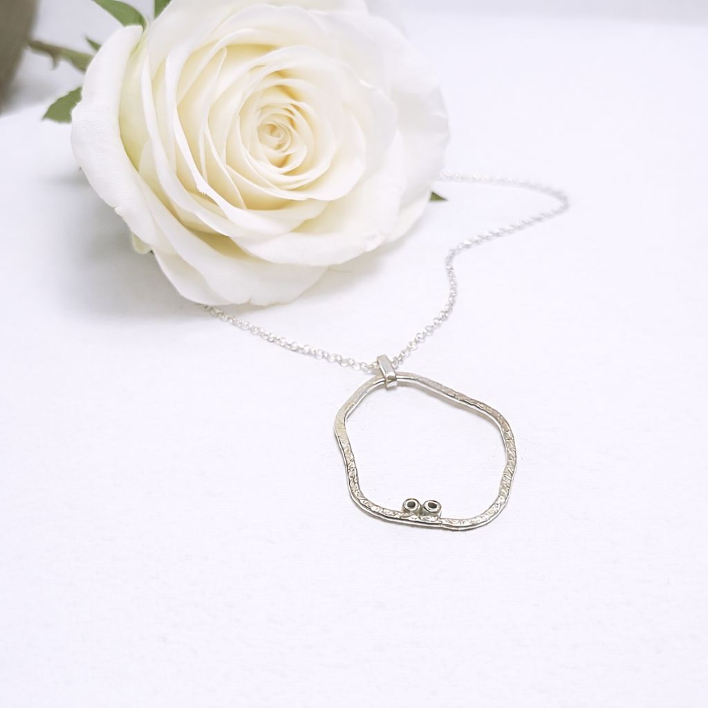 Organic silver pendant with two small eggs