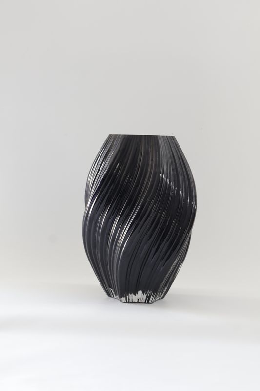 Dark black glass vase features a dynamic, twisted spiral design