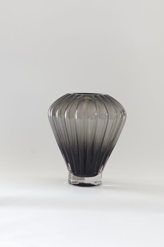 ​Smoked grey glass vase features a balloon-shaped design with ribbed vertical facets: