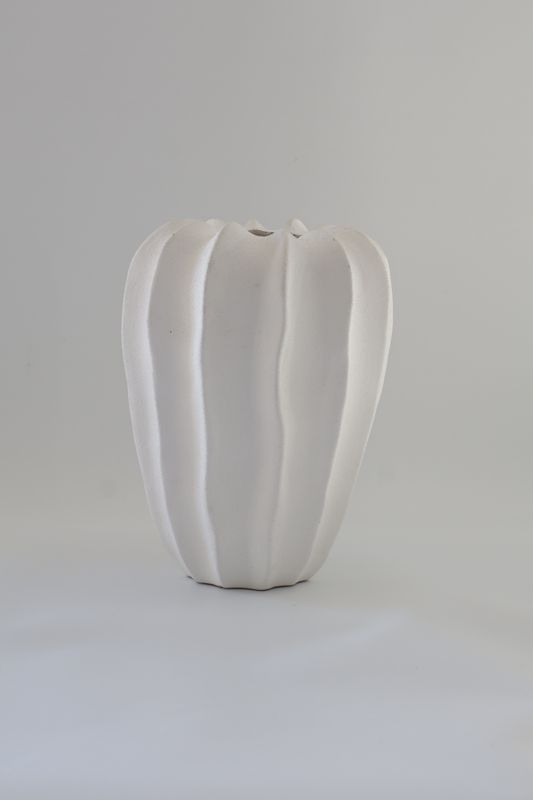 ​White ceramic vase features a bold, ribbed melon/cactus-like design