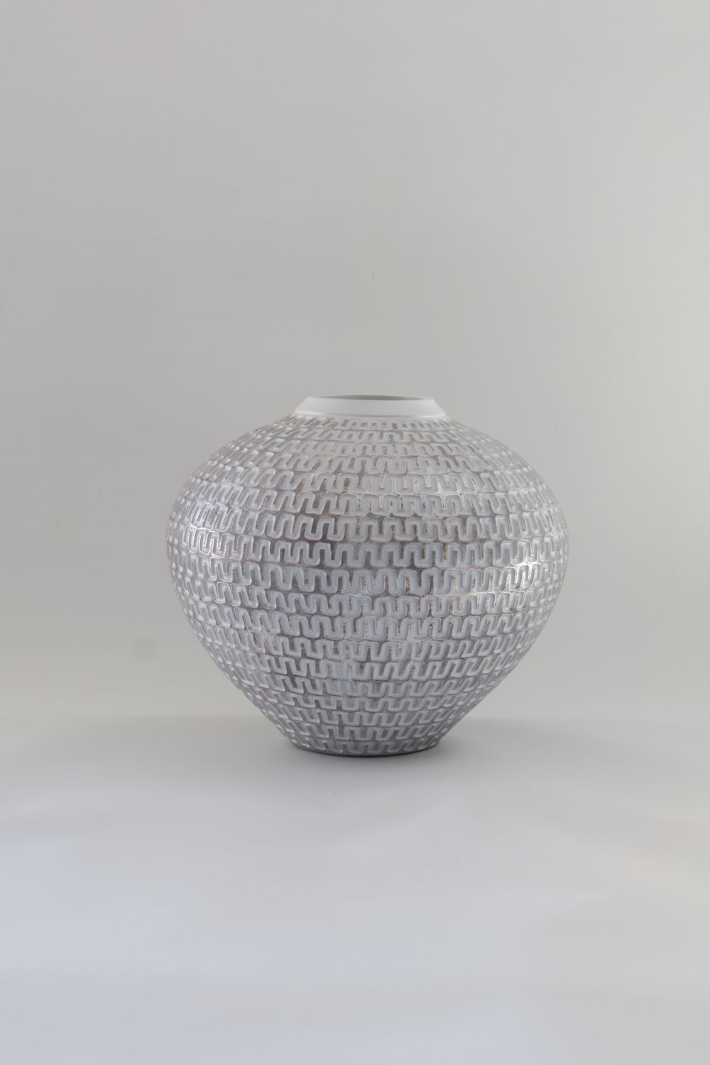 ​This ceramic sphere vase features a textured geometric pattern