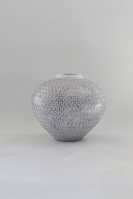 ​This ceramic sphere vase features a textured geometric pattern