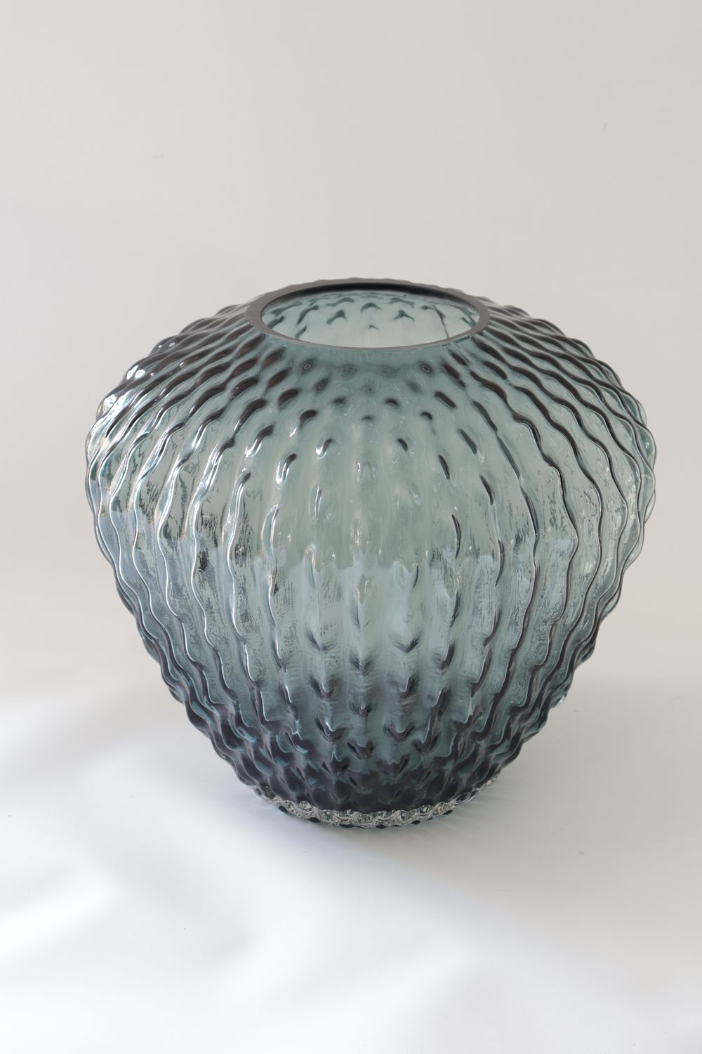 Dark grey / smoked glass vase features a wide bulbous shape with a dimpled, vertical-grooved surface.
