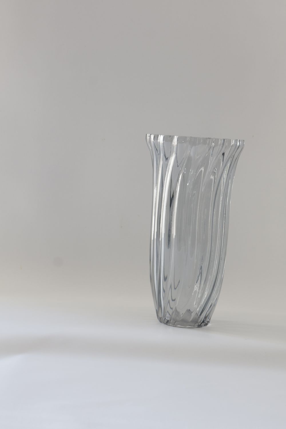 Clear glass vase features a twisted fluted design