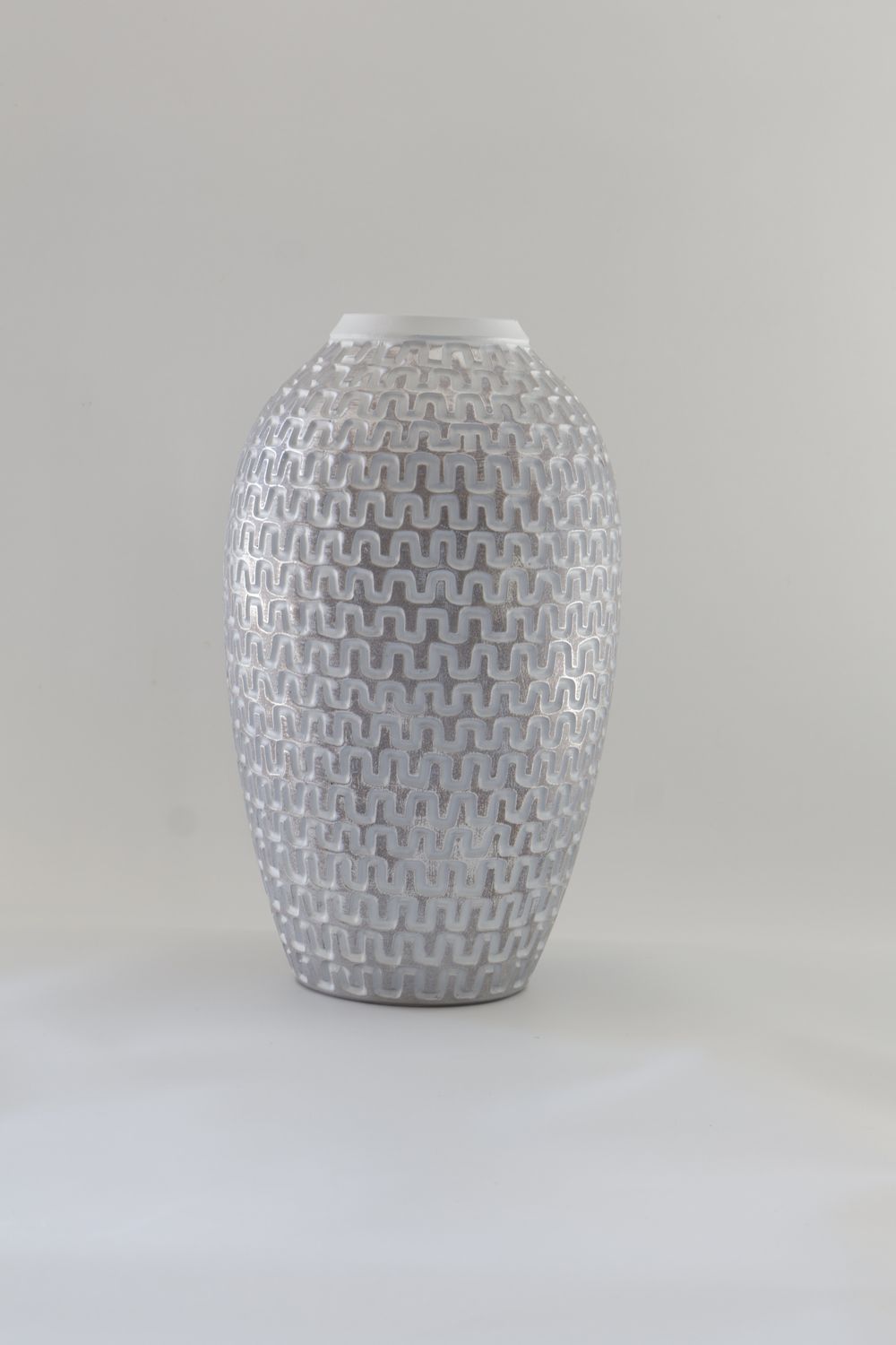 Ceramic vase features a tall, tapered silhouette with an intricate geometric woven texture.