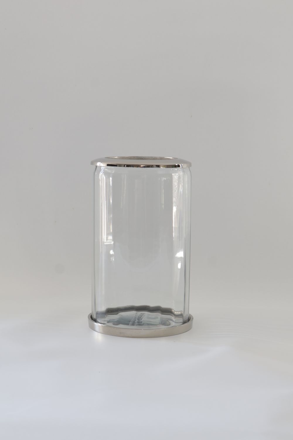 ​Minimalist straight-sided glass cylinder with metallic trims.