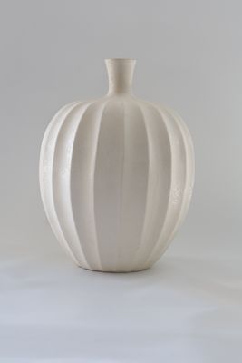 Modern pumpkin-shaped or lobed bottle silhouette with vertical ribbed fluting.