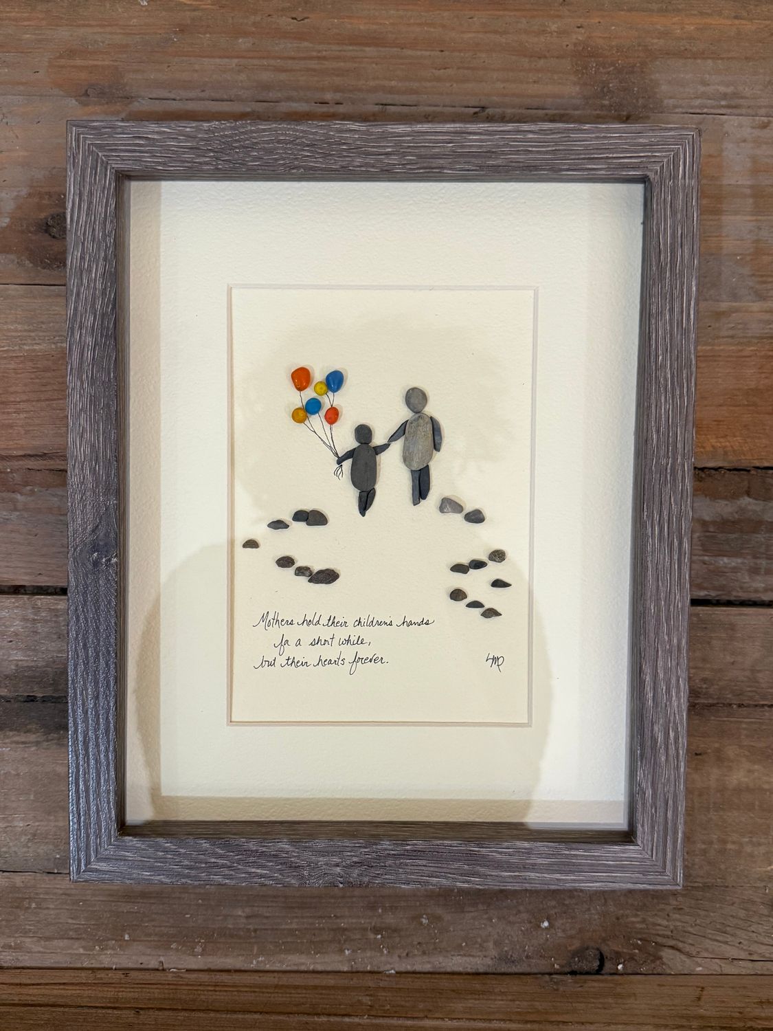 Mothers hold hearts pebble art