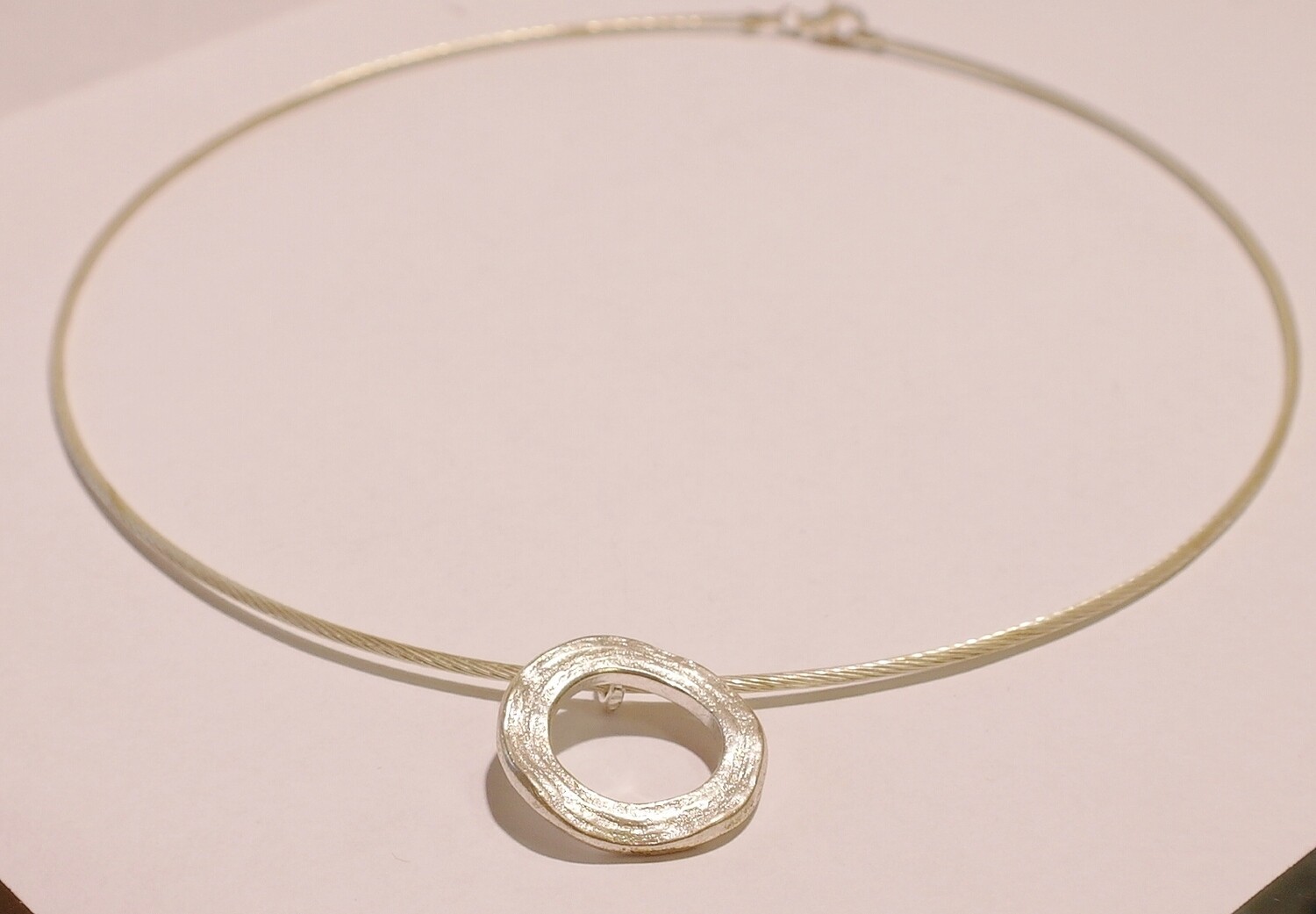 Silver pendant on a wire collar