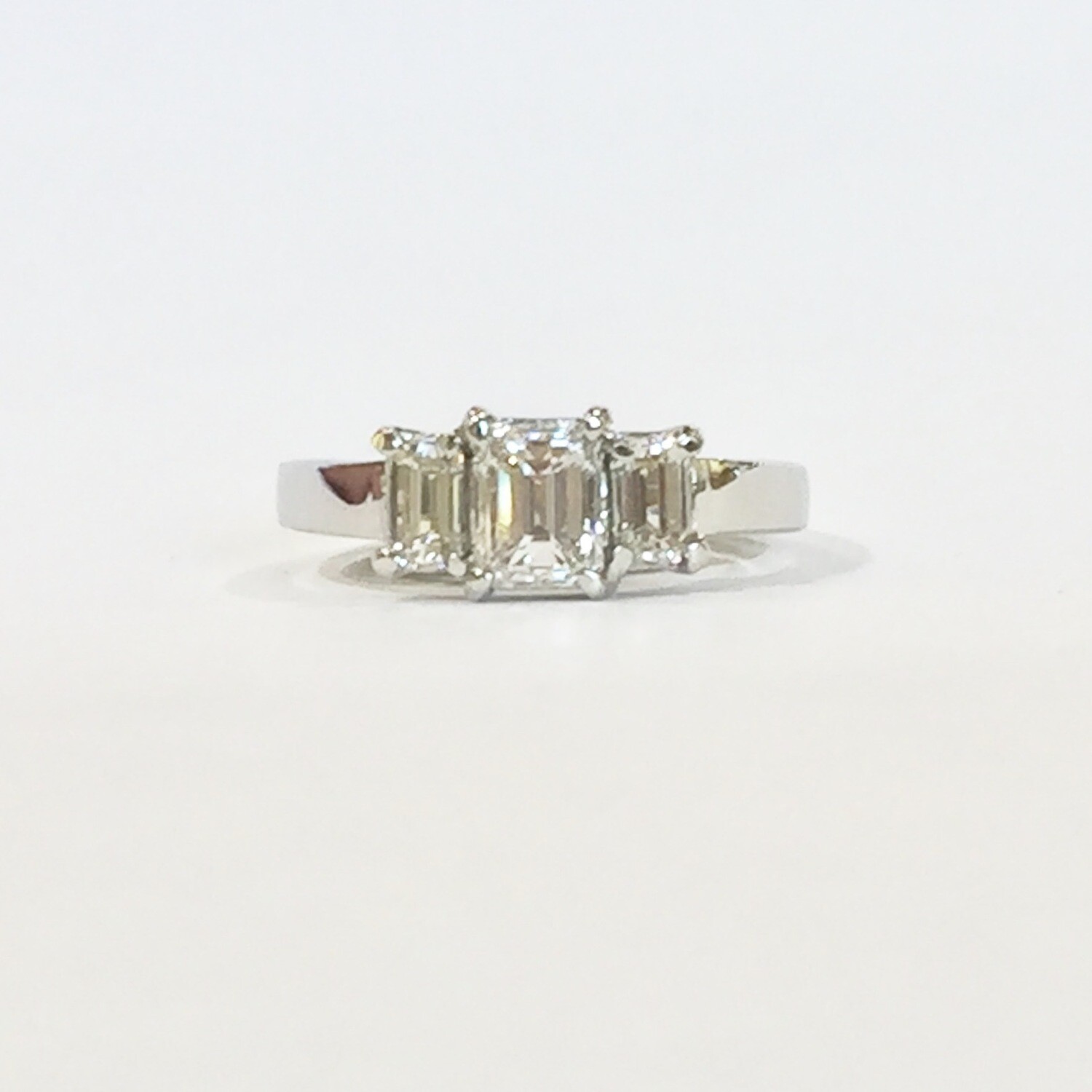 Platinum emerald cut diamond three stone ring