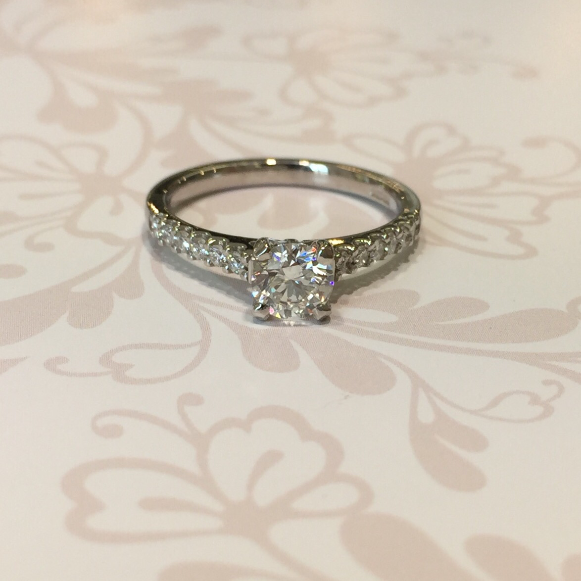 Platinum brilliant cut diamond ring with brilliant cut shoulders