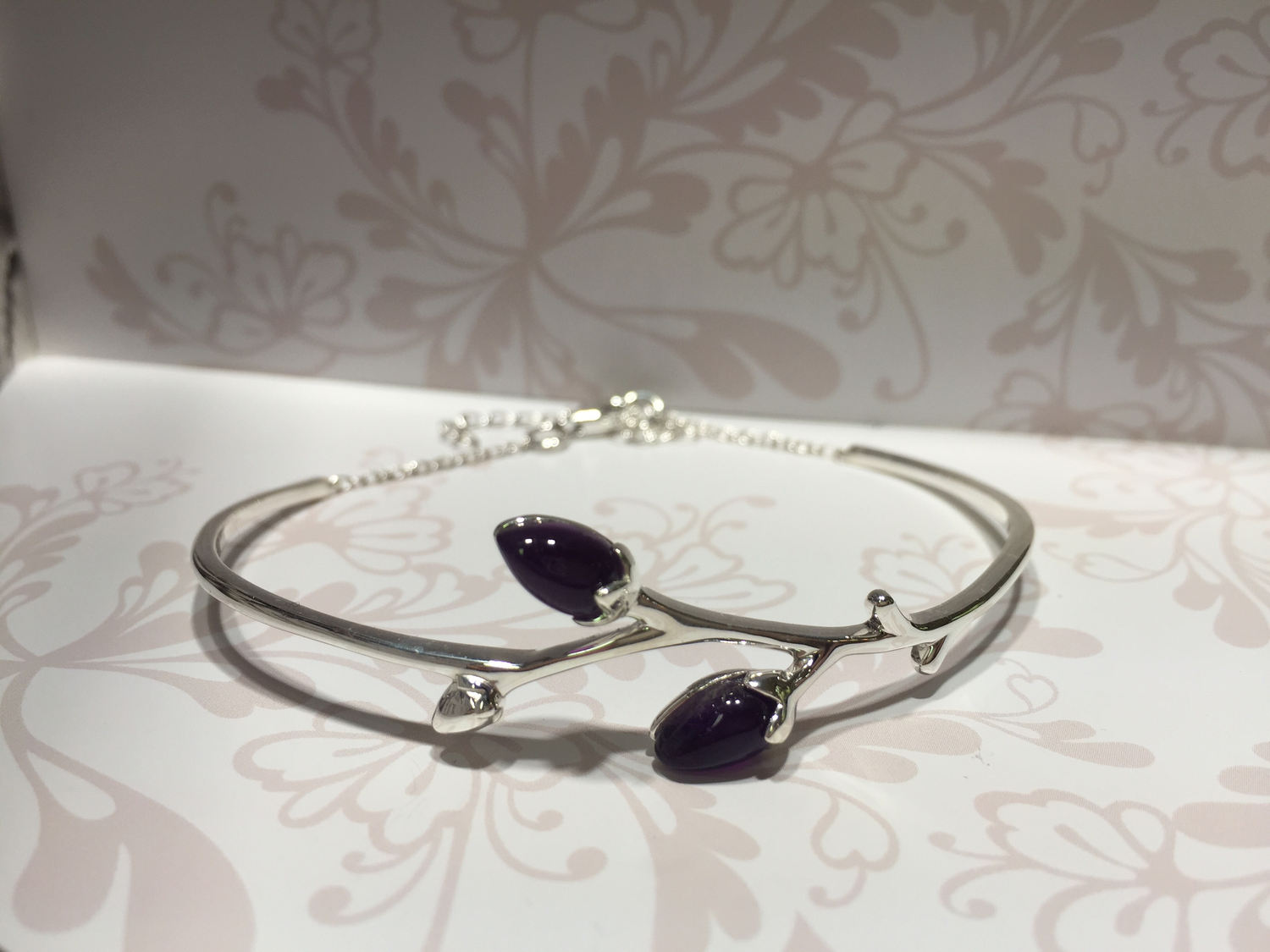 Silver bangle with purple coloured stone