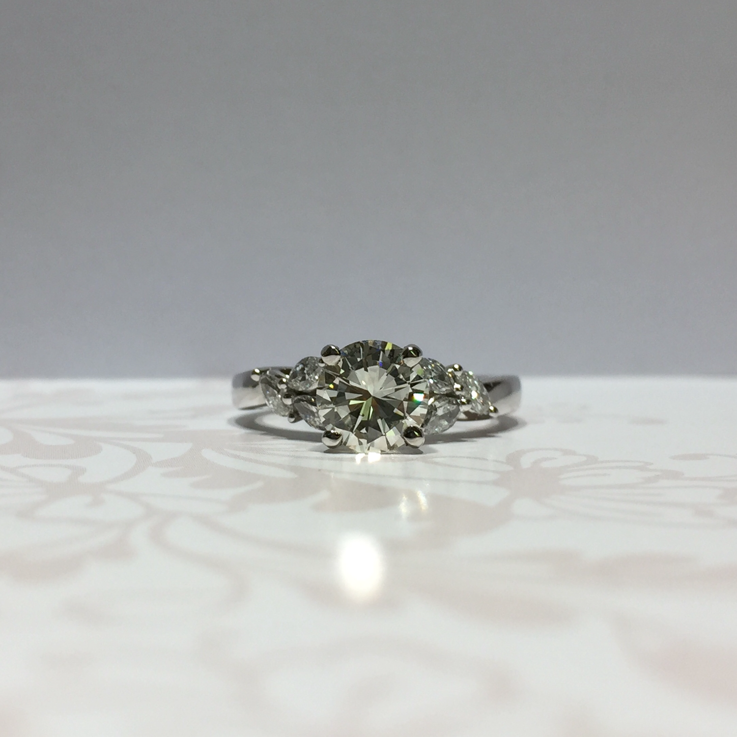 Platinum brilliant diamond ring with marquise diamond shoulders