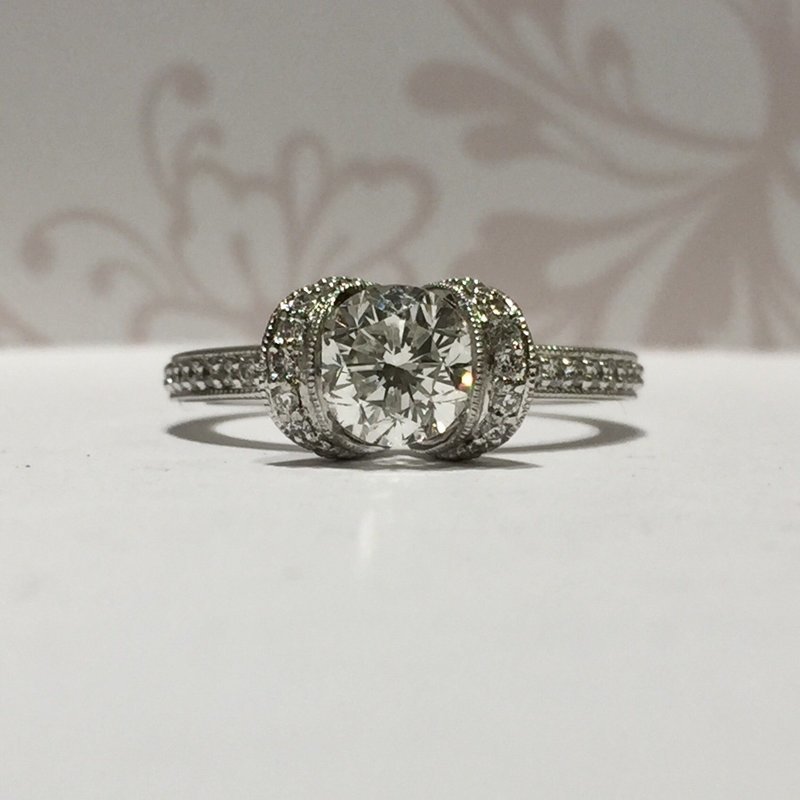 Platinum brilliant cut diamond with pave diamond tension setting and pave diamond shoulders