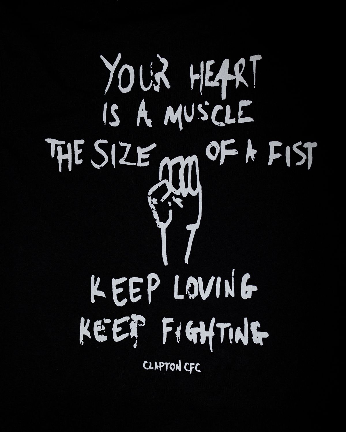 Close up of the design with a fist and the words 'Your Heart Is a Muscle the Size of a Fist, Keep Loving, Keep Fighting'