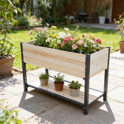 Raised wood and iron garden bed with flowers and a lower shelf on a patio.