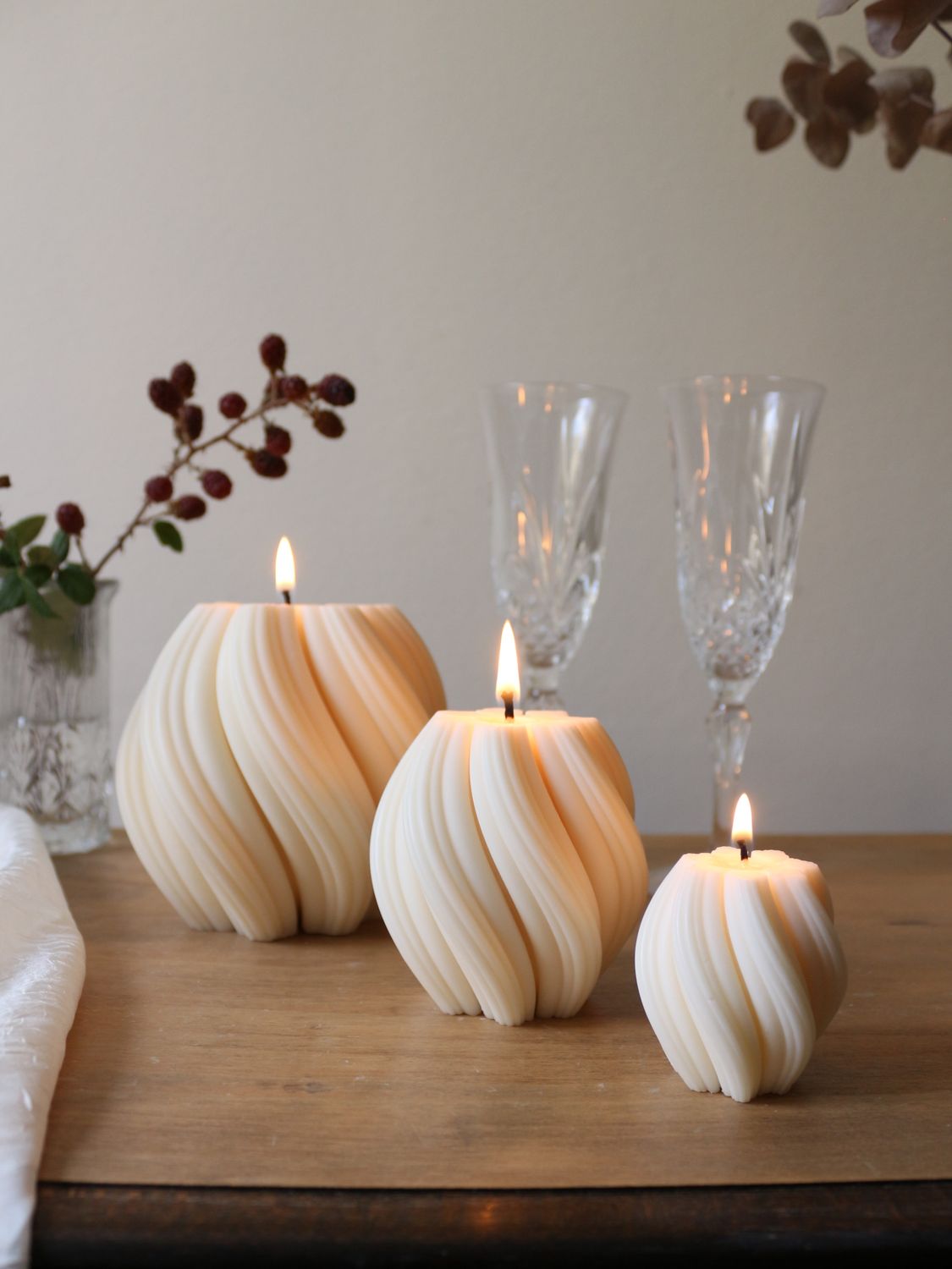 Set di tre candele bianche a spirale in tre misure, accese