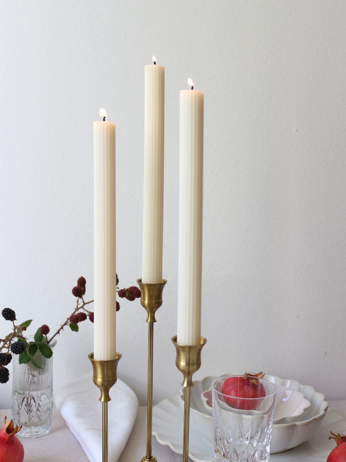 tre candele decorative a stelo a costine in candelieri dorati, accese