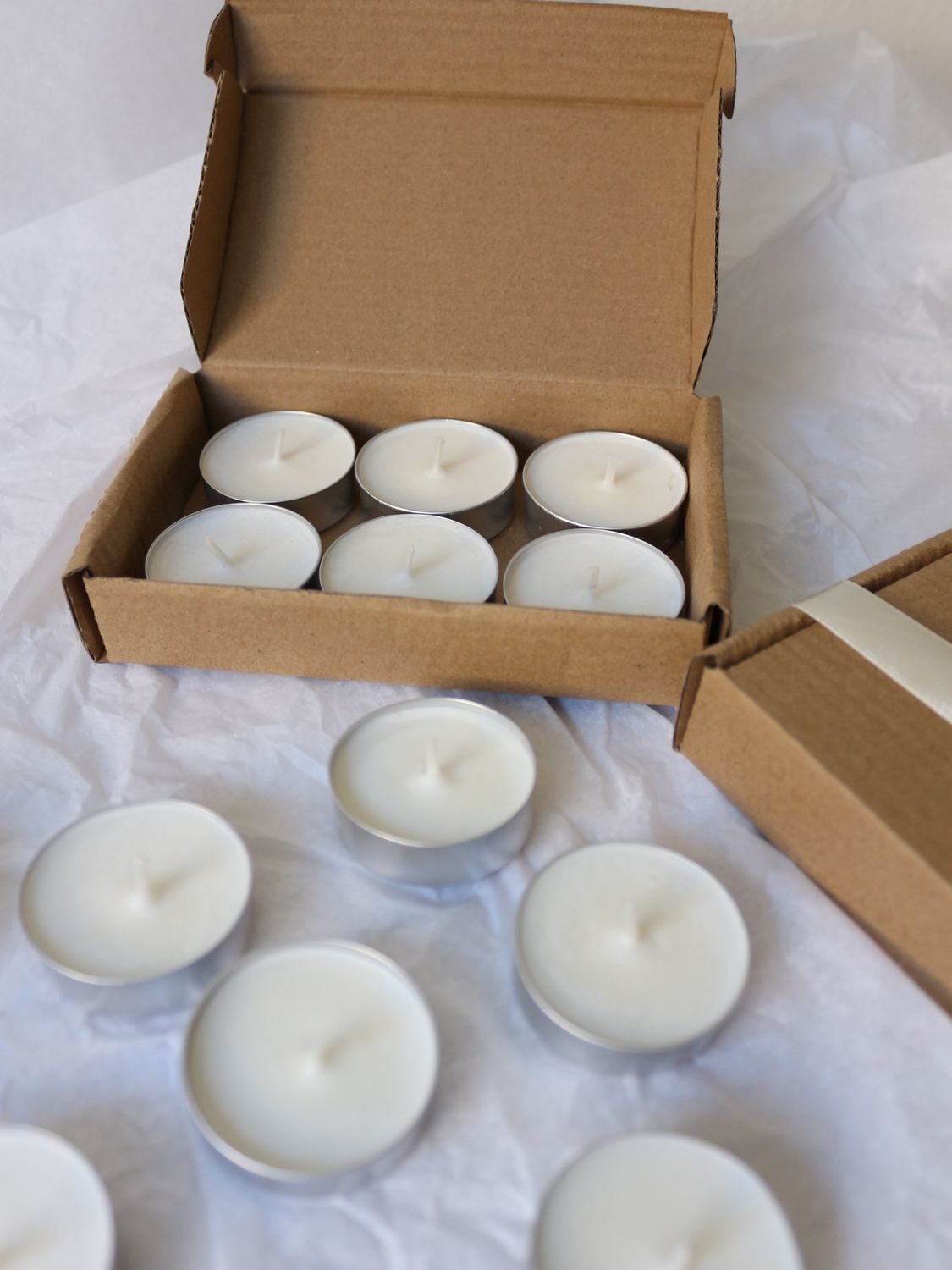 Scatola con sei tea light e quattro sfuse in primo piano