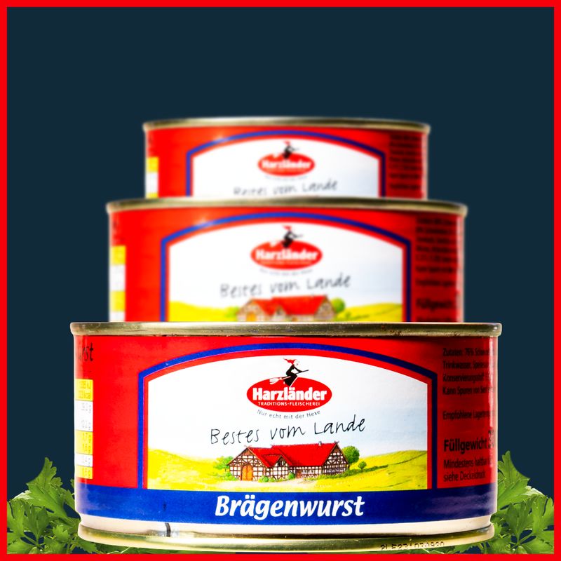 Drei übereinandergestapelte rot-weiße Brägenwurst-Dosen auf dunklem Hintergrund