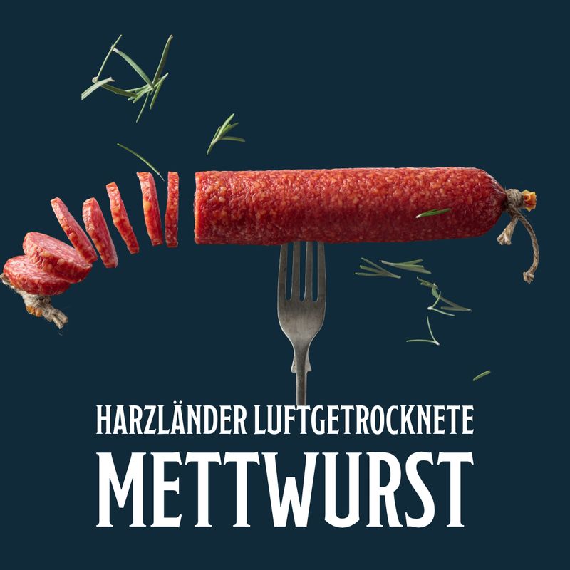 Harzländische Rohwurst, rot und in Scheiben geschnitten, auf dunkelblauem Hintergrund mit Gabel und
