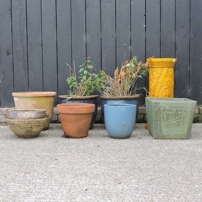 Lot 50,   A yellow glazed Burmantofts jardiniere stand, 65cm high, together with a plastic garden storage cupboard, 70cm, and a collection of garden pots (8) 30/50