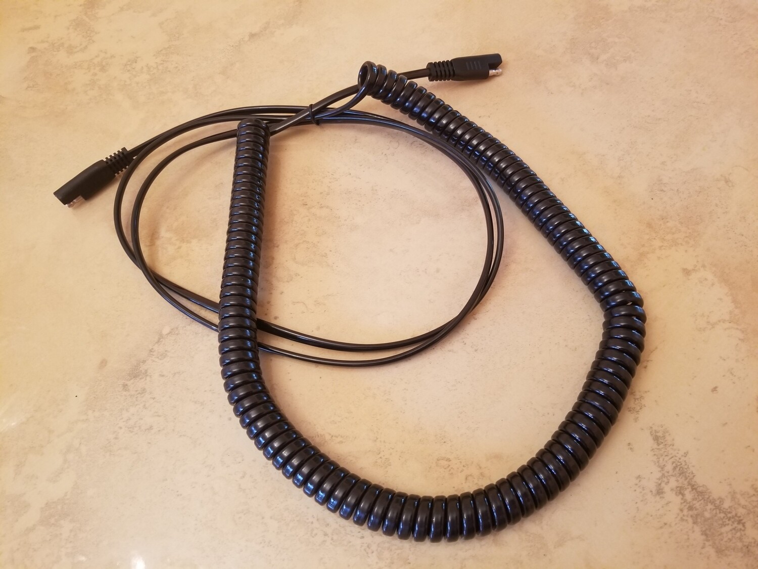 Coiled extension cord for car battery. 2 SAE plugs