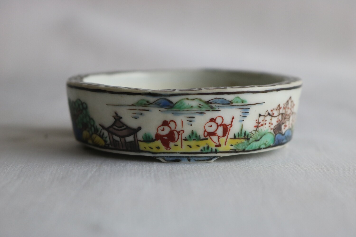 Kutani Nishiki; Japan.   7.7 cm; Porcelain; Round; Hand-Painted; 5 Colour; Sages; Greek Key Painted Rim;