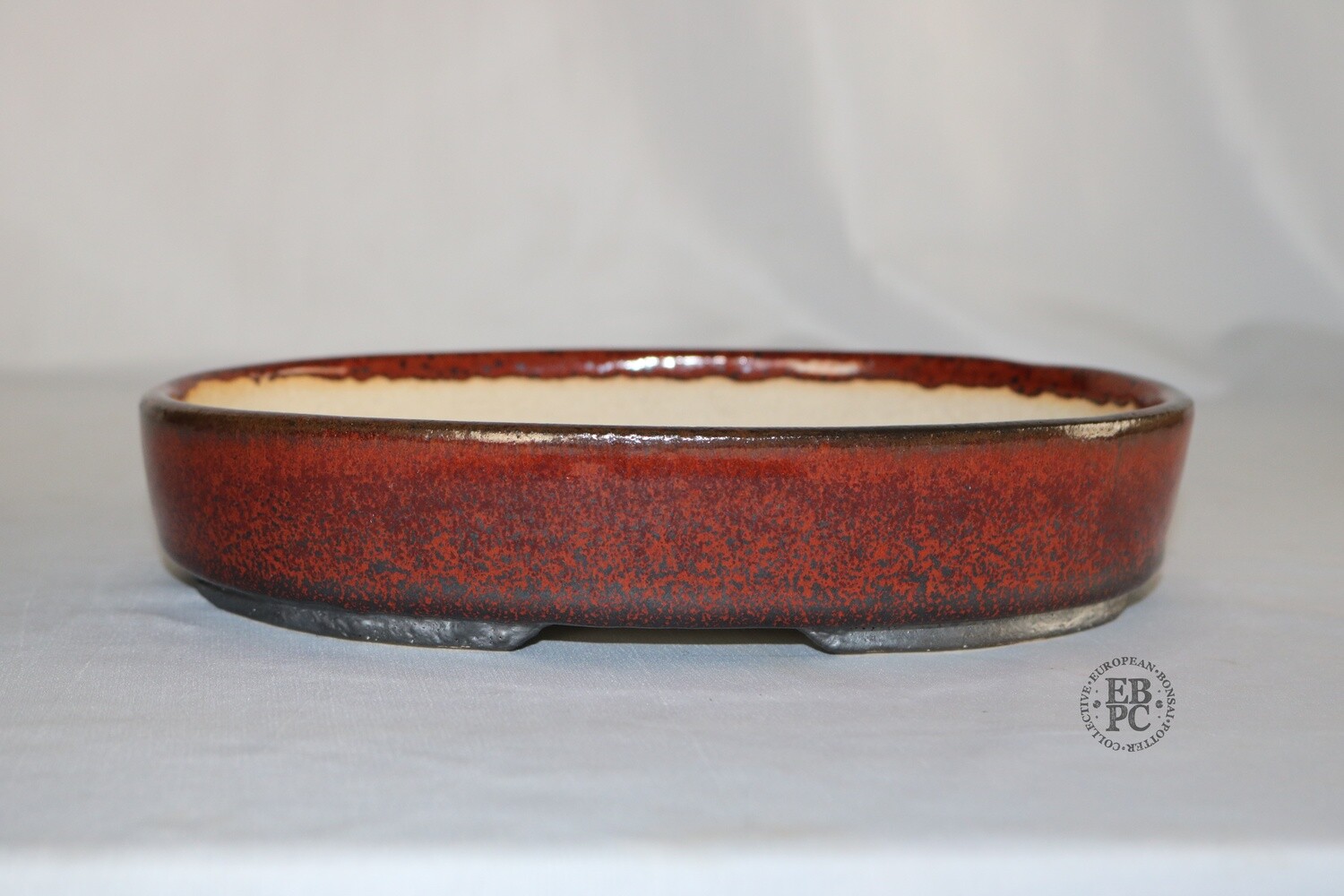 Sabine Besnard - 18.3cm; Glazed; Oval; Kaki Glaze; (Persimmon); Reds; Black; Gunmetal;