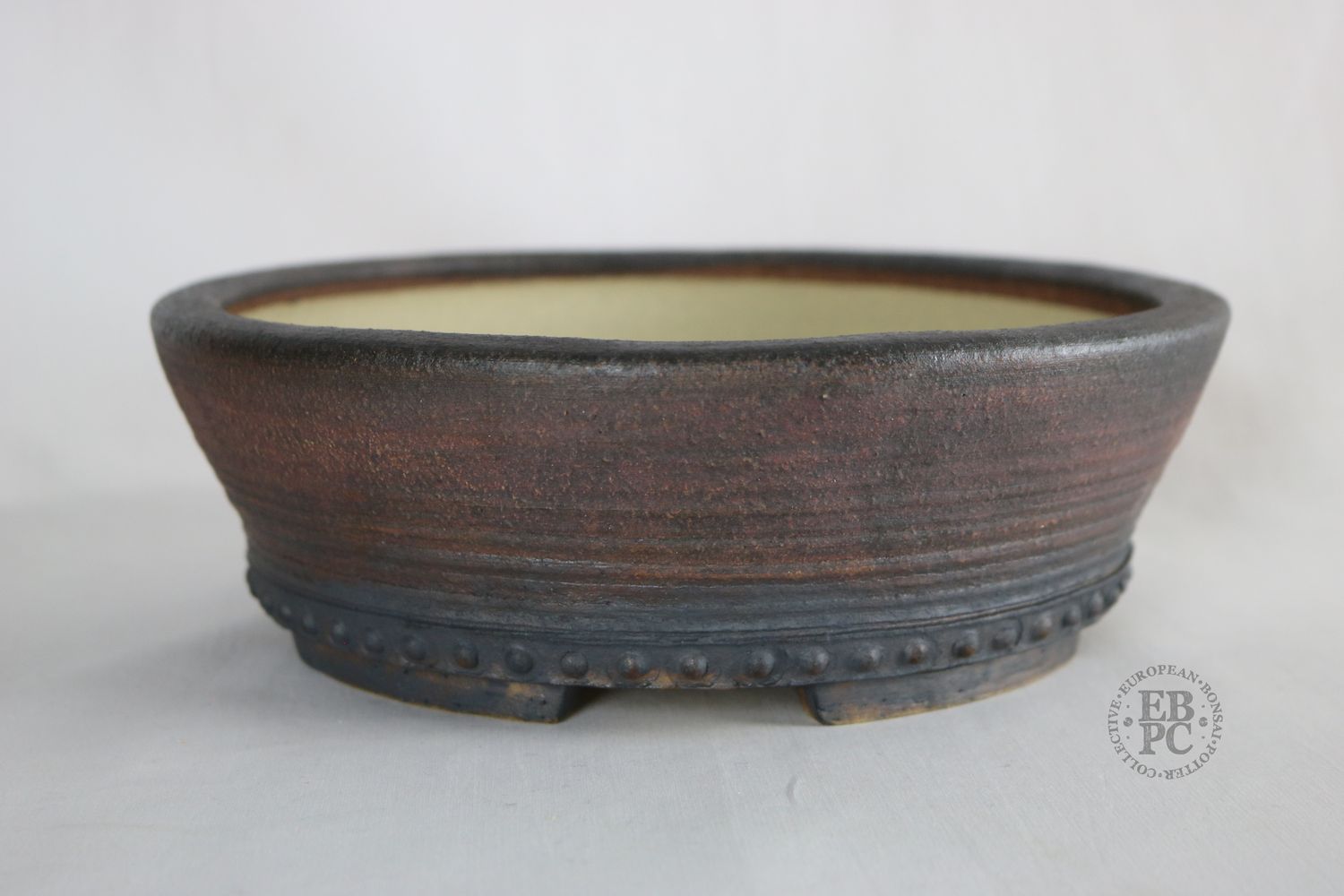 Ian Baillie - 23.8cm; Unglazed; Generous Depth; Light Clay; Rivets; Subtle Ridged Detail; Browns; Red Tones; Charcoal Grey; Rustic; Aged looking; Hand-signed; EBPC Stamped