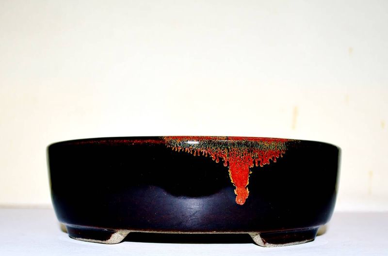 SATOMI Terahata - Tokoname.   15.8cm; Oval; Glazed; Almot Black; Tenmoku glaze; Brilliant Red Flash;  * Offered on behalf of a client. .