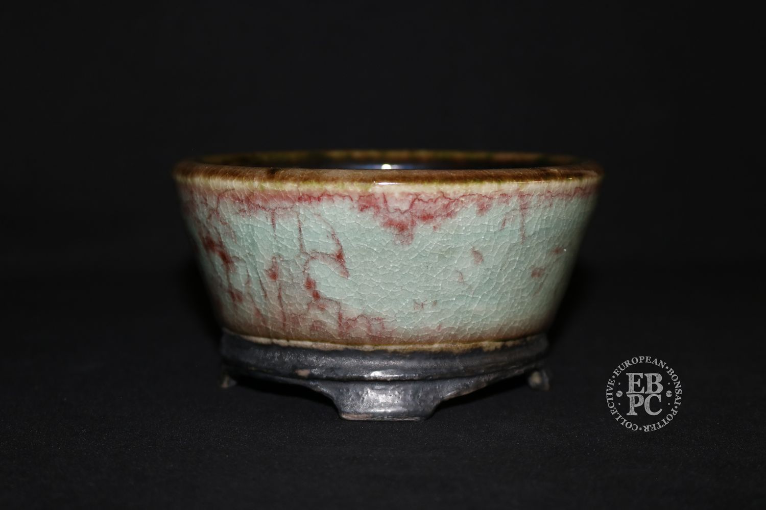 Eddie Curtis, England   - 12.8cm; Hand-thrown; Round;  Exceptional Celadon Glaze; Blood-Red Veins; Crackle Effect; Basal Band; Oxide Finished Carved Feet; Stamped with EBPC &amp; Artist&#39;s Logo.