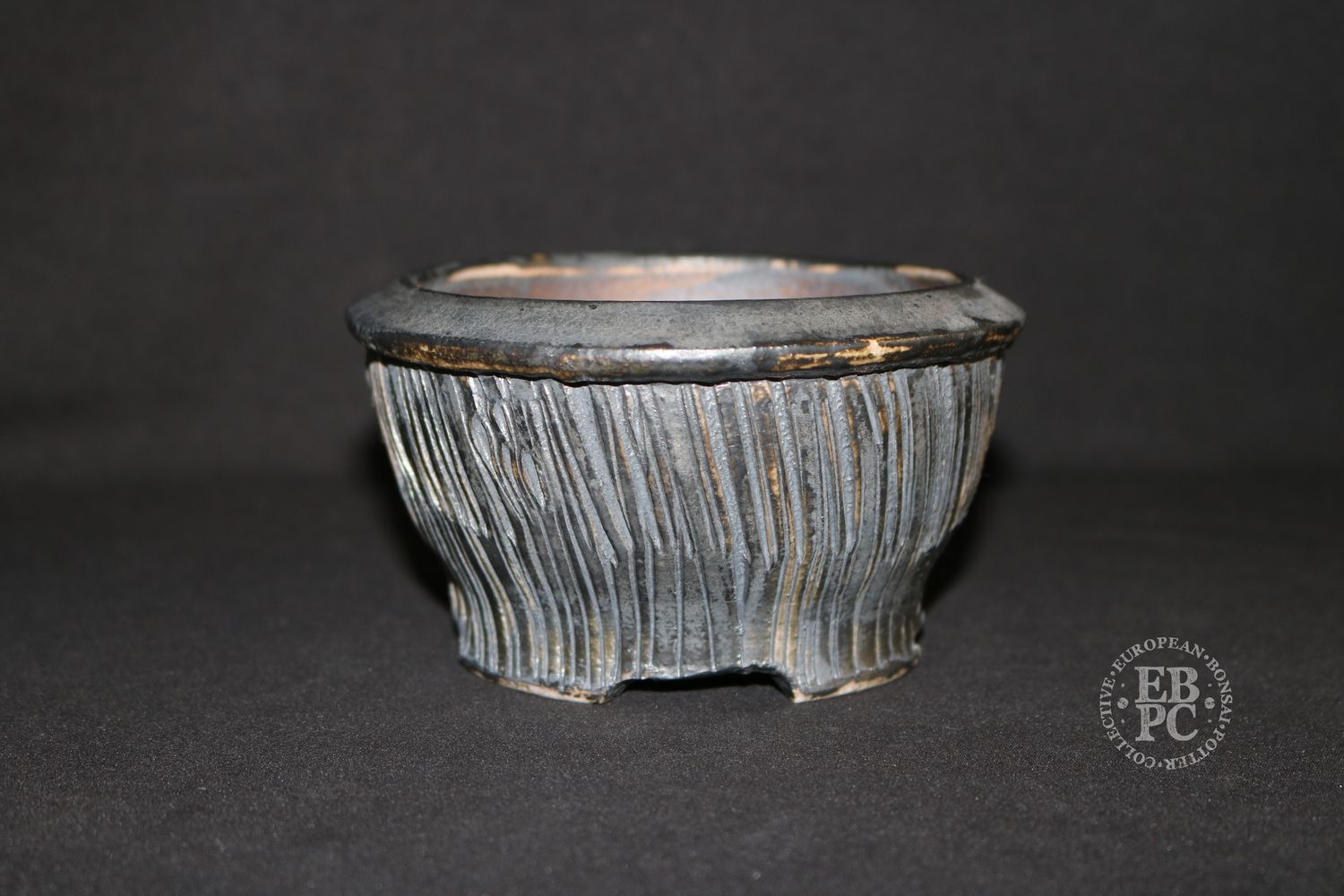Eddie Curtis, England.   - 13.3cm; Hand-thrown; Round; Ribbon-like Texture; Gunmetal Grey; Browns; Glaze &amp; Oxide Finished; Foot Ring &amp; Feet; Stamped by the Artist.